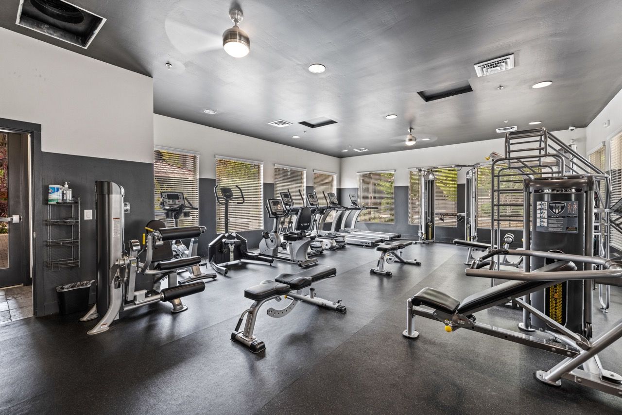 Interior of a modern community gym with treadmills, weight machines, and benches at Mountain Trail, offering apartments for rent in Flagstaff near NAU.