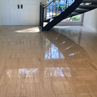 A shiny tiled floor with a staircase in the background