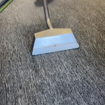 A vacuum cleaner is being used to clean a carpet.