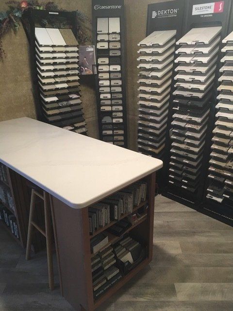 Display of sample flooring planks and countertops in a showroom corner