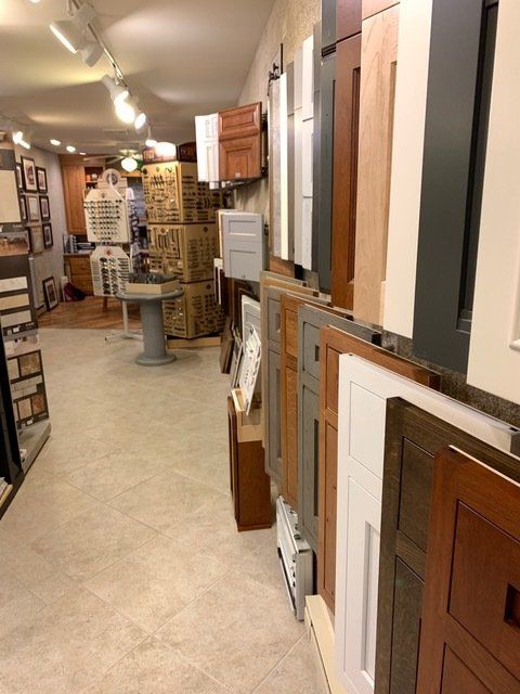 Interior of a store aisle displaying framed doors, cabinet panels, and wall samples in a showroom