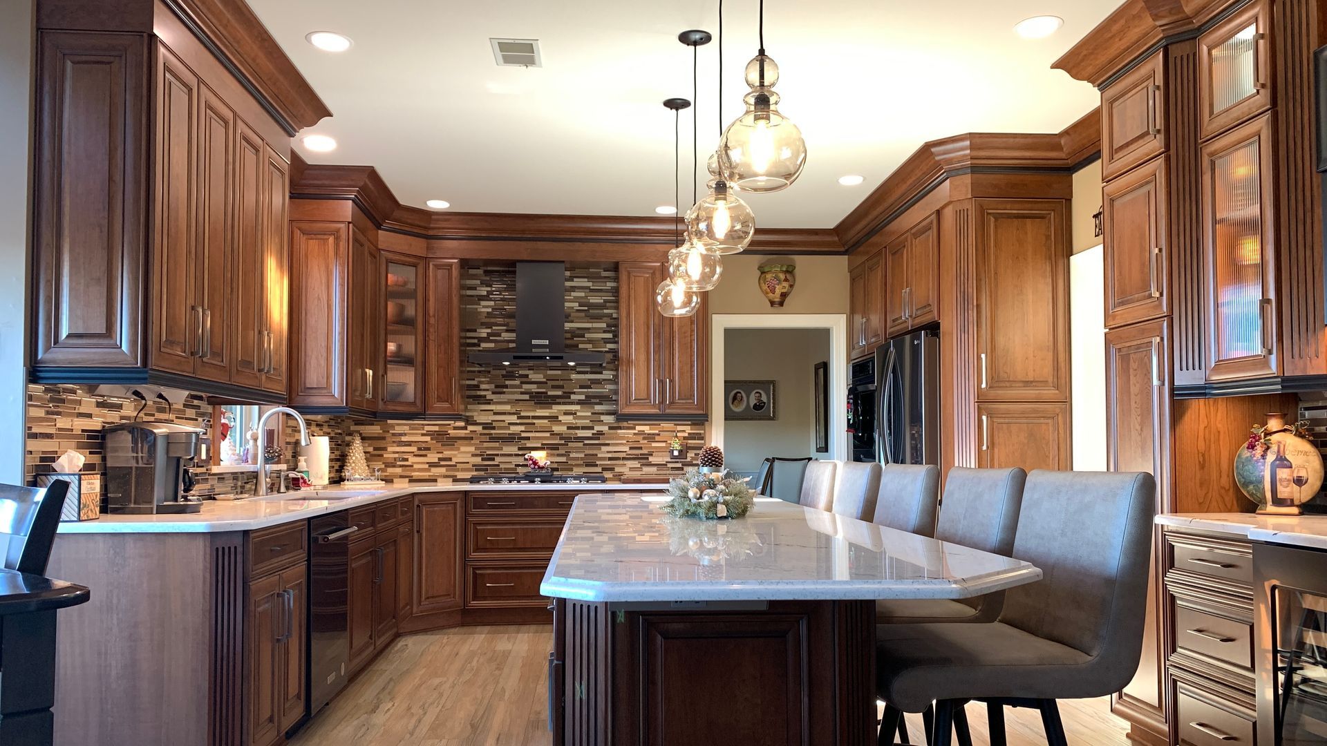 Modern kitchen with dark wood cabinets, stone island, and pendant lights