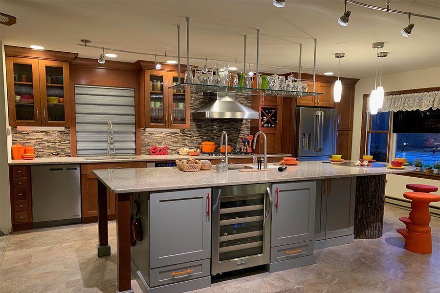 Modern kitchen with a large island, stainless appliances, wood cabinets, and warm lighting