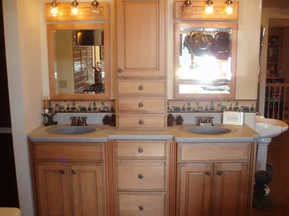 Double-sink bathroom vanity with wooden cabinets and framed mirrors under warm lights