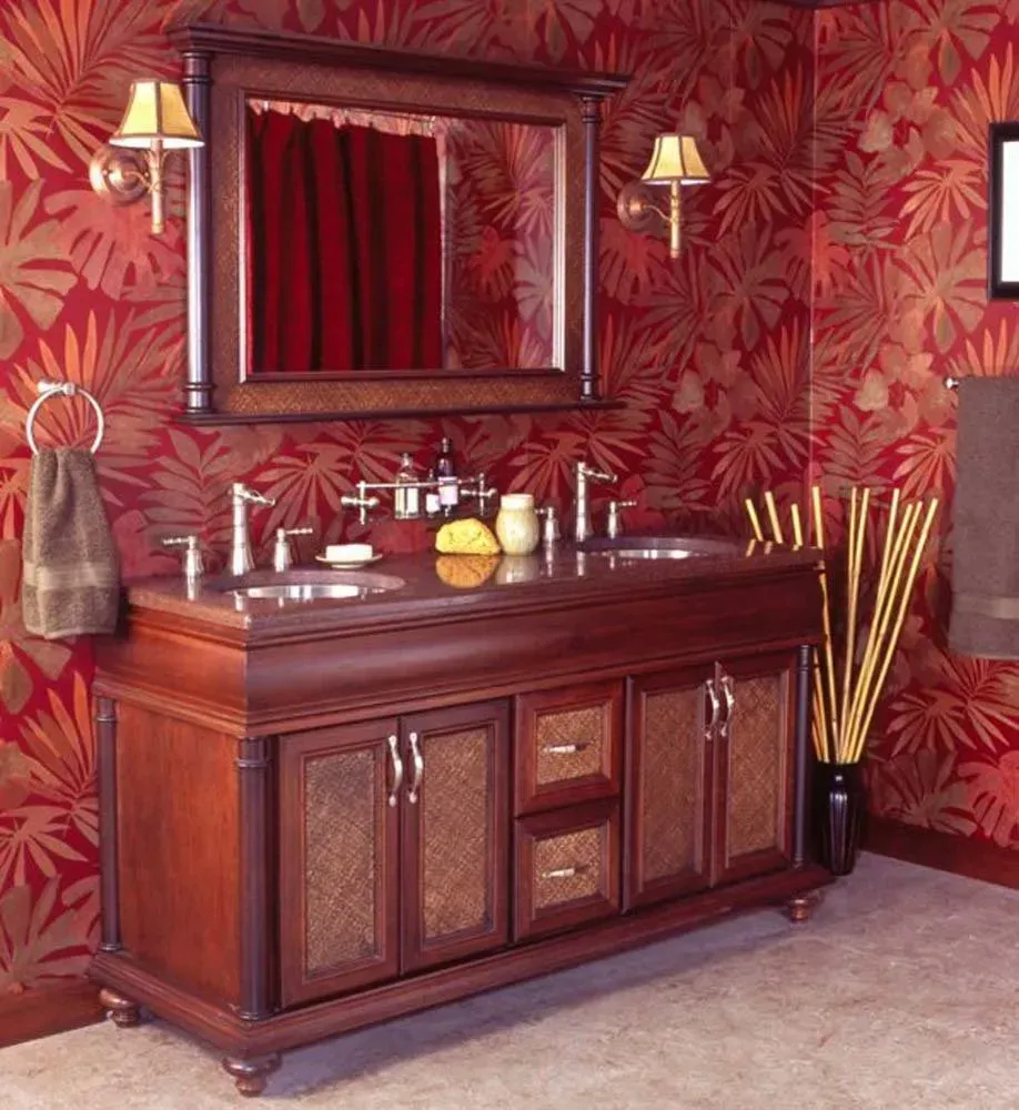 Elegant bathroom vanity with dark wood cabinet, red patterned wallpaper, mirror, sconces, and beige tile floor