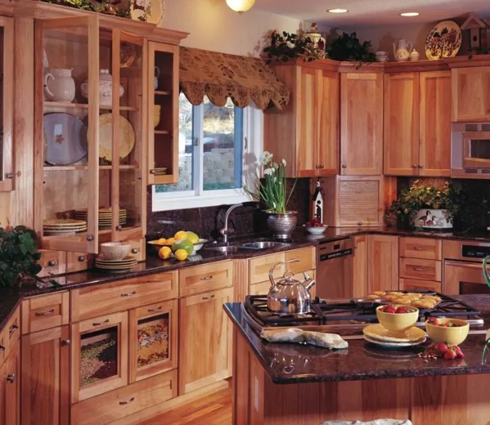 Warm wood kitchen with island, cabinets, window over sink, and fruit bowls on the counter.