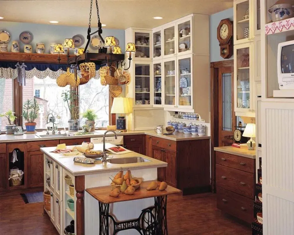 Cozy country kitchen with island, wooden cabinets, hanging pot rack, and large windows with curtains