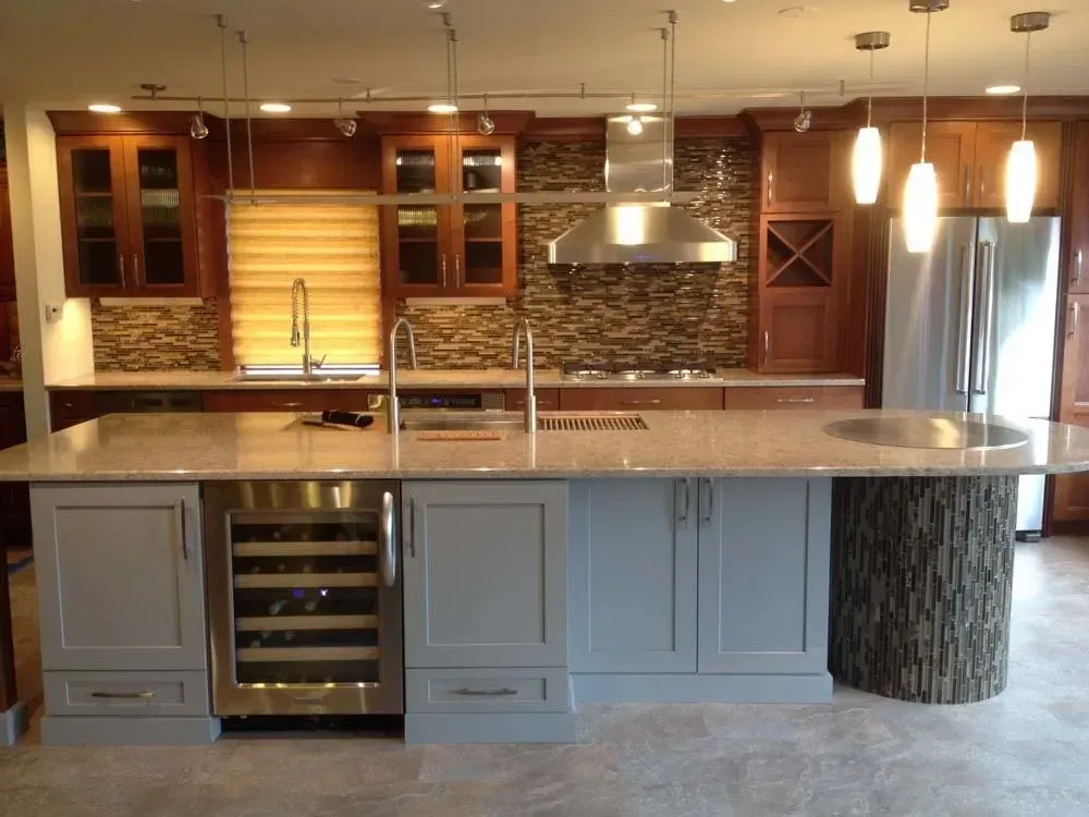Modern kitchen with large island, wood cabinetry, pendant lights, and stainless steel appliances