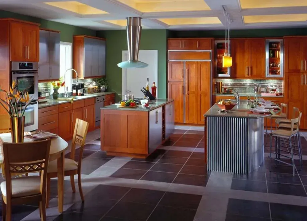 Modern kitchen with wood cabinets, central island, and tiled floor in warm lighting