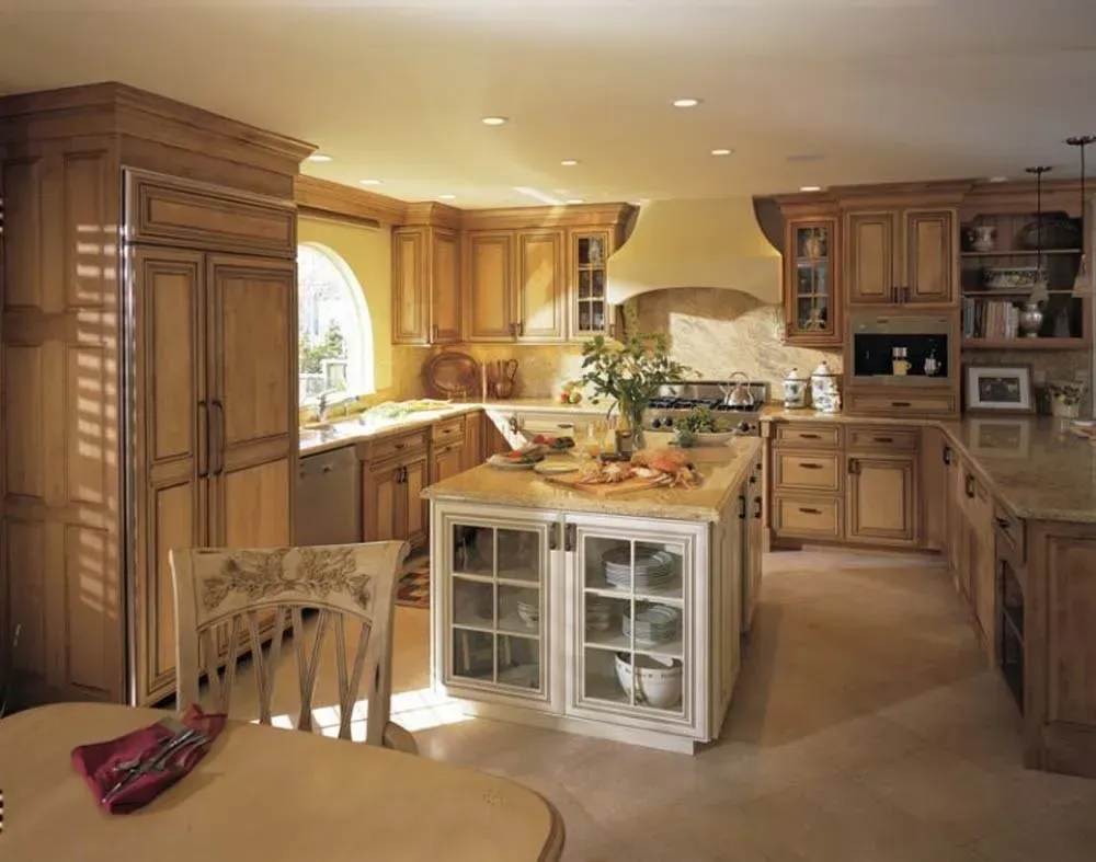 Warm, rustic kitchen with wooden cabinets, island, arched window, and glass-fronted storage.