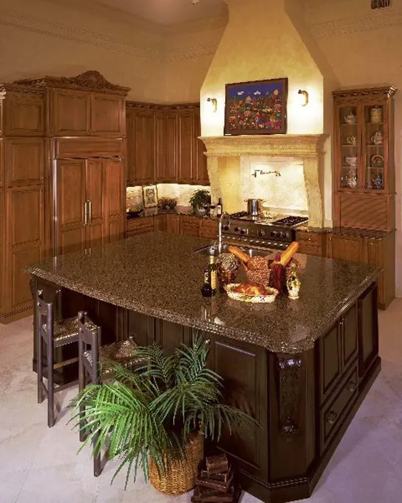 Elegant kitchen with dark wood cabinets, large island, and granite countertops in warm lighting