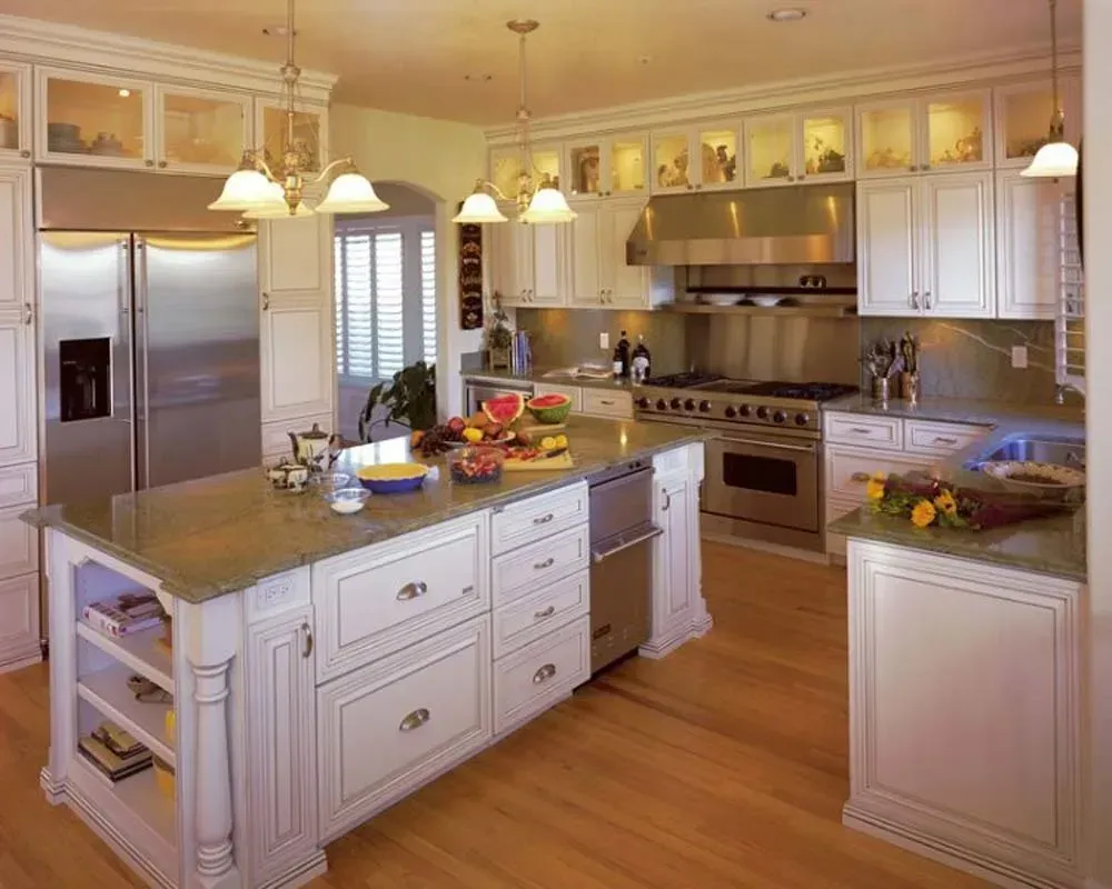 Bright modern kitchen with white cabinets, stainless steel appliances, island, and warm wood floors