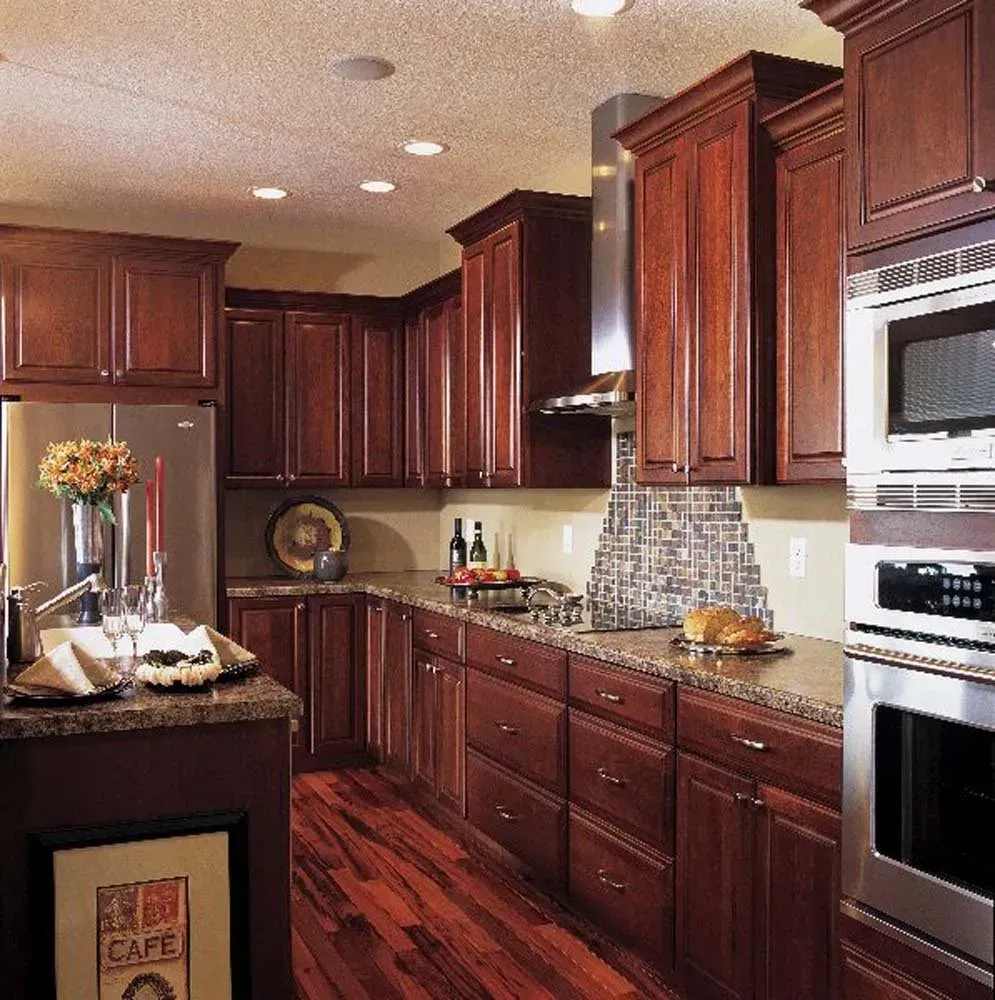 Modern kitchen with dark wood cabinets, granite island, mosaic backsplash, and stainless steel appliances