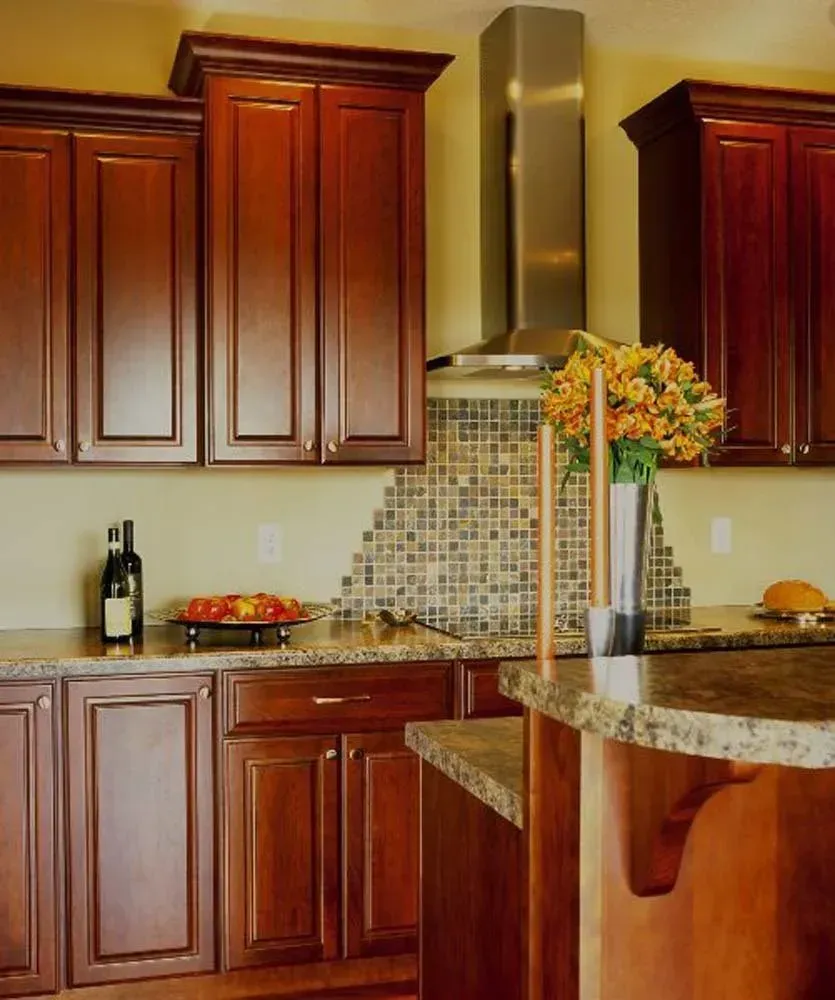 Modern kitchen with dark wood cabinets, granite countertops, mosaic backsplash, and stainless steel range hood