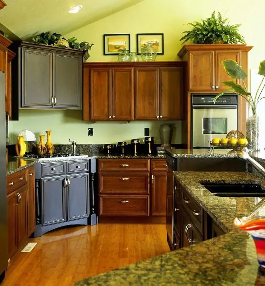 Modern kitchen with dark wood cabinets, granite counters, and stainless steel appliances, in warm yellow walls