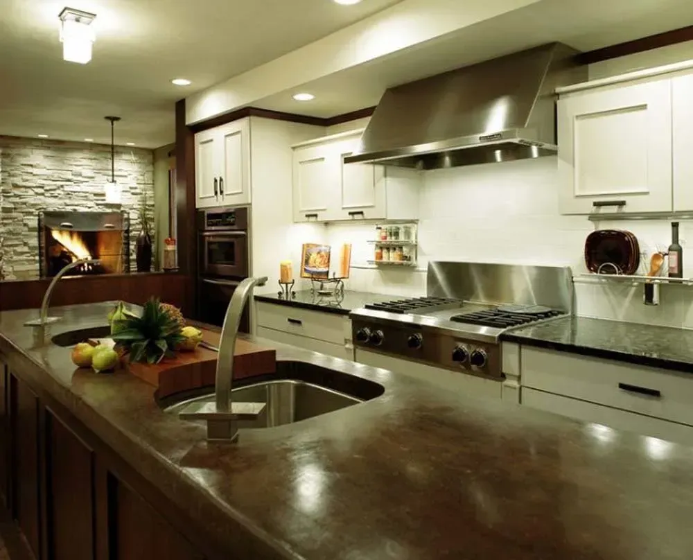 Modern kitchen with stainless-steel appliances, dark island countertop, and white cabinets