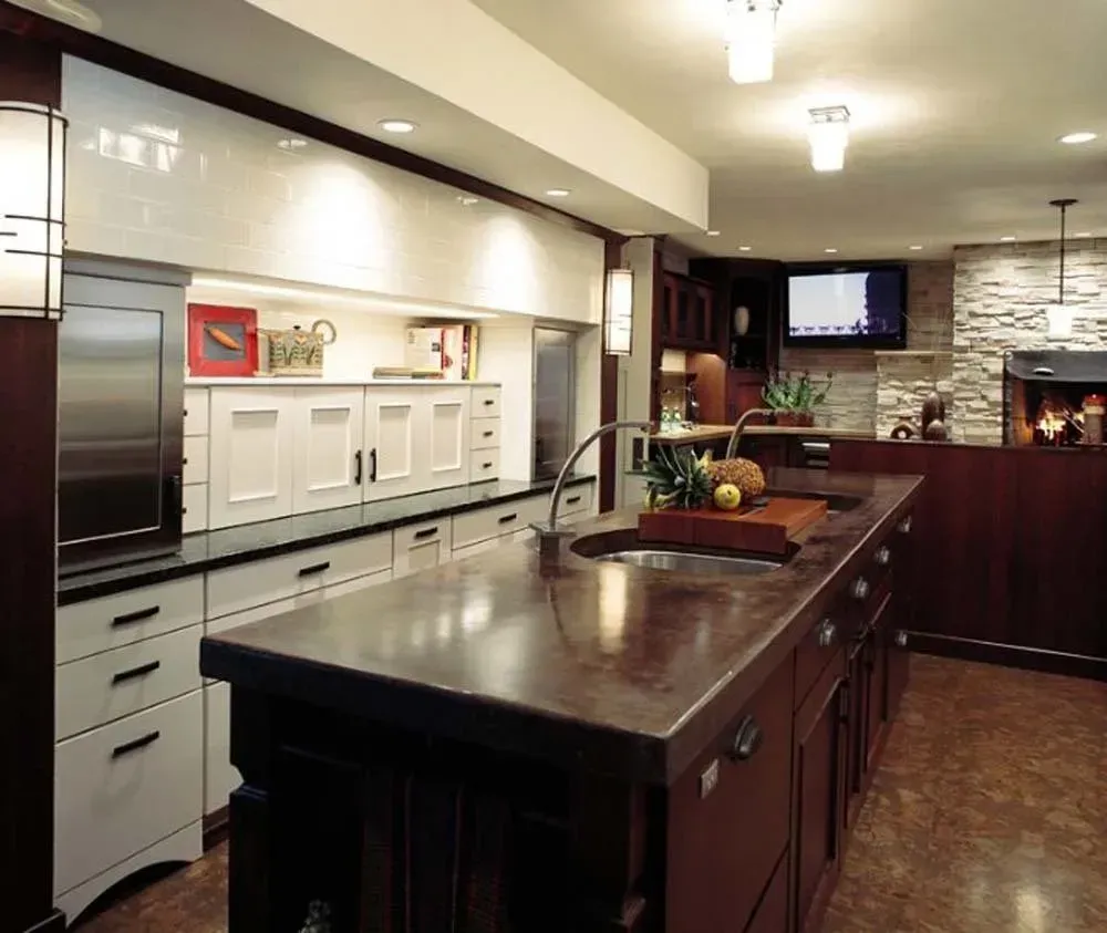 Modern kitchen with dark wood island, white cabinets, and stone backsplash beside a dining area