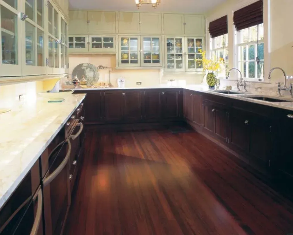Bright kitchen with dark wood cabinets, white countertops, and hardwood floor, viewed from the center