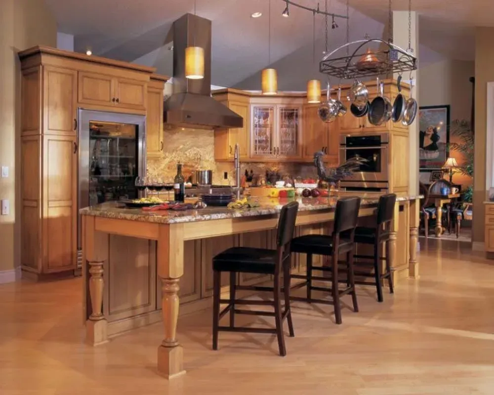 Modern kitchen with island, bar stools, warm wood cabinets, and pendant lighting