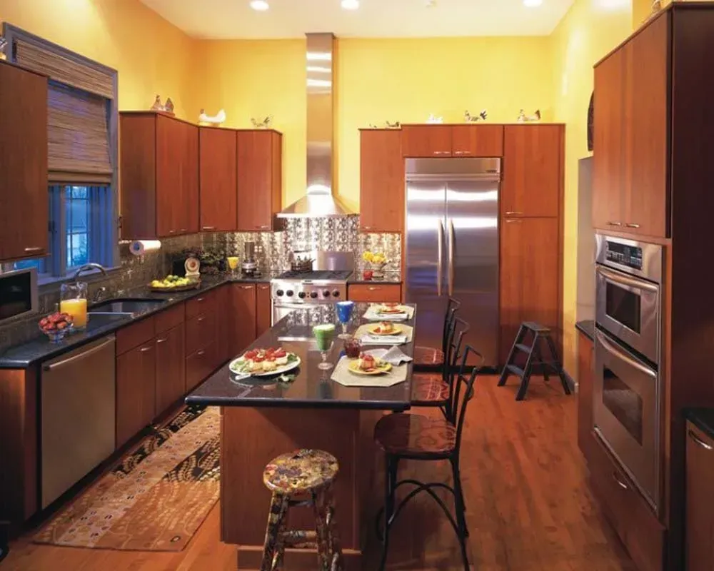 Modern kitchen with dark wood cabinets, stainless steel fridge, and a table set for a meal