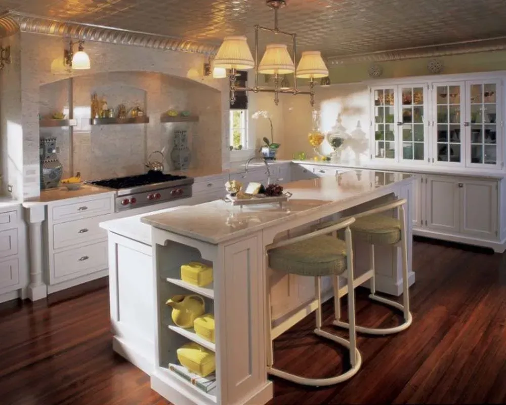Bright modern kitchen with white island, stools, hardwood floors, and stainless appliances