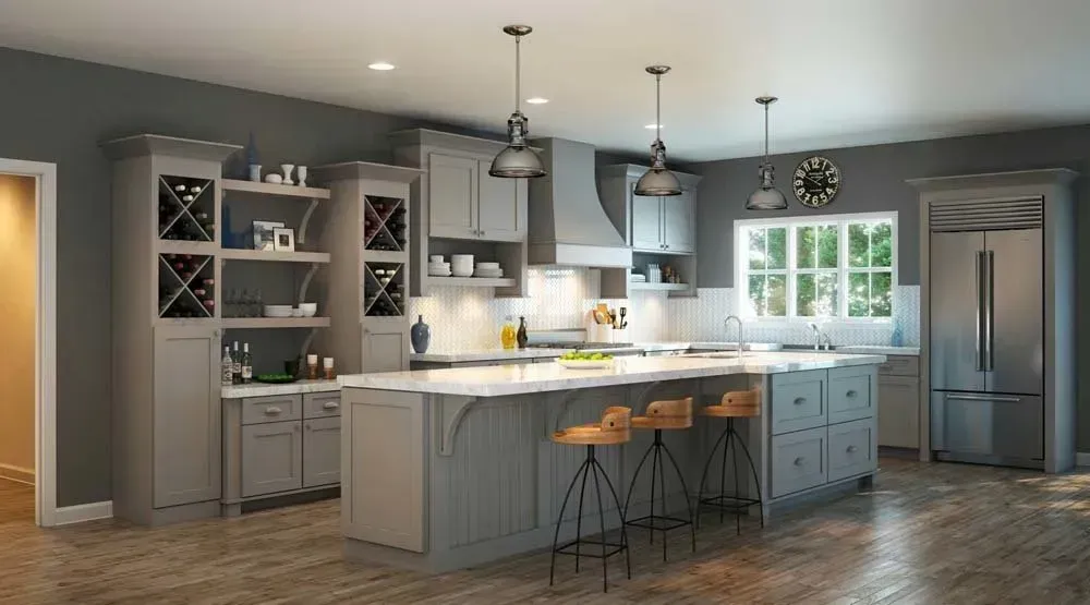 Modern gray kitchen with island, pendant lights, bar stools, and stainless steel refrigerator.