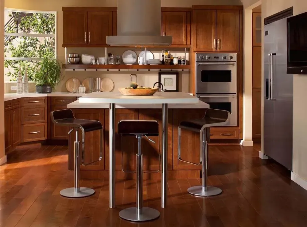 Modern kitchen with a central island, four stools, wooden cabinets, and stainless steel appliances