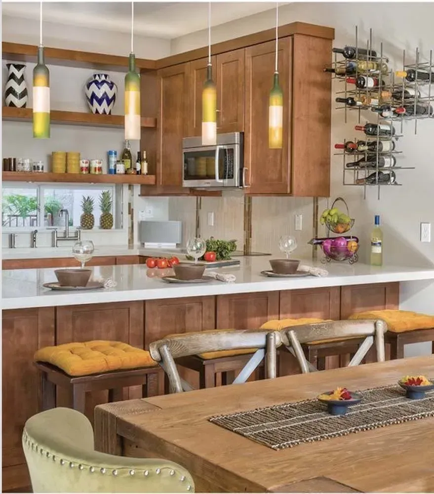 Modern kitchen with wooden cabinets, pendant lights, and a breakfast bar with stools