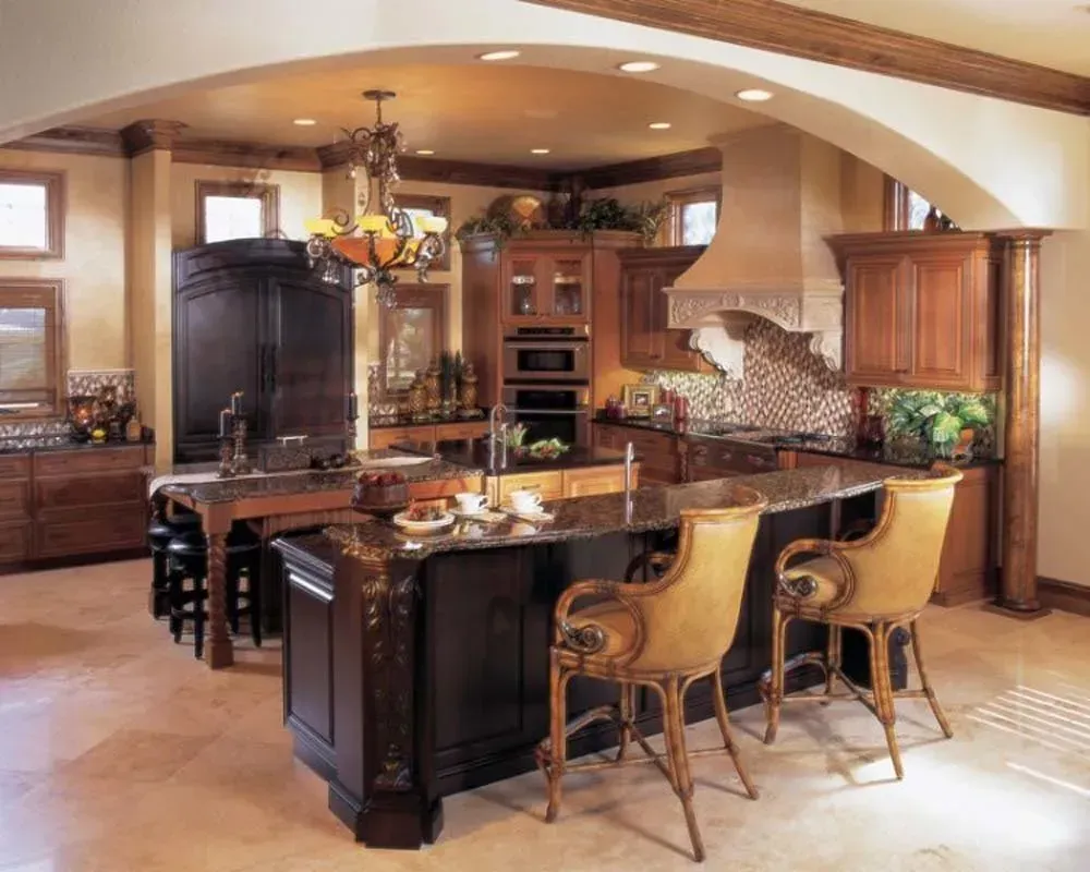Warm-toned gourmet kitchen with dark wood island, bar stools, and arched ceiling.