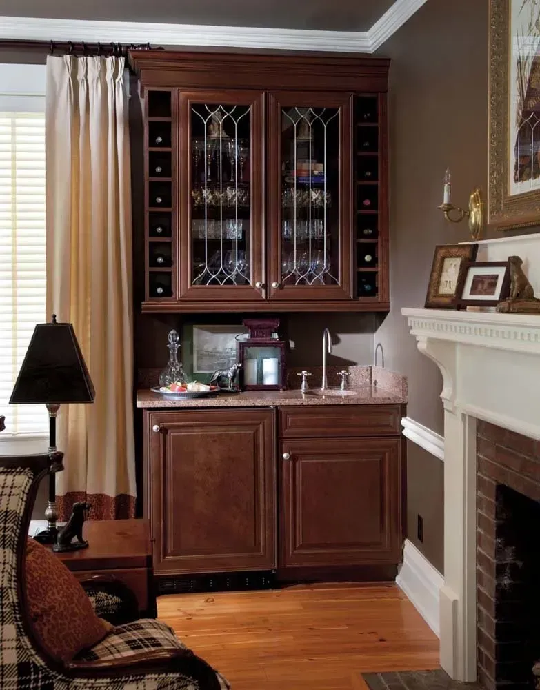Traditional living room corner with wood cabinet, lamp, leather chair, and white fireplace mantel