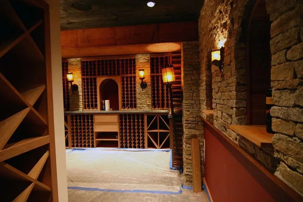 Dimly lit brick wine cellar with wooden racks and stone walls