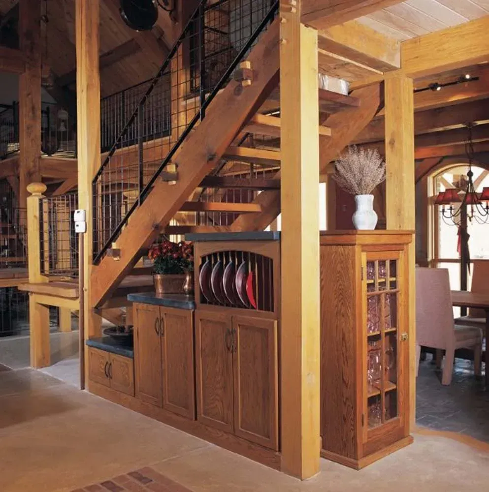 Rustic wooden interior with a staircase, built-in cabinetry, and a dining area in the background