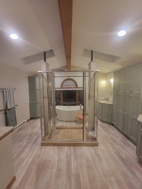Modern bedroom with a four-poster bed, mirrored wardrobe, and light wood flooring