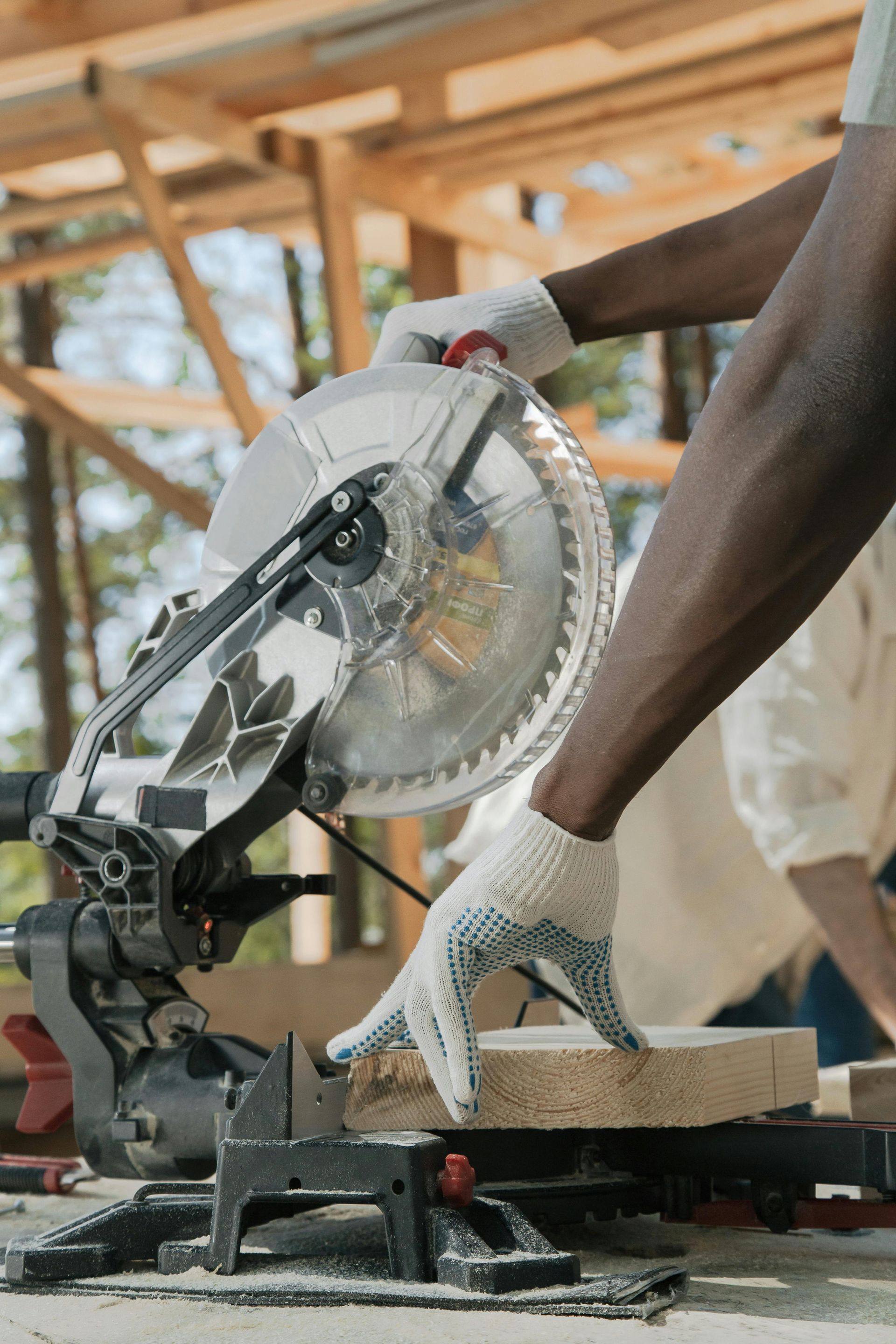 A man is using a circular saw to cut a piece of wood.