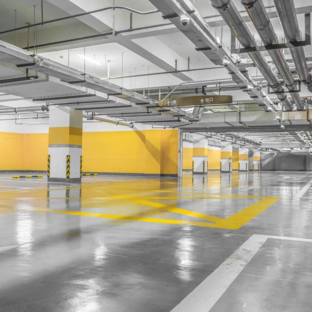 Empty parking garage with yellow pillars and floor markings.
