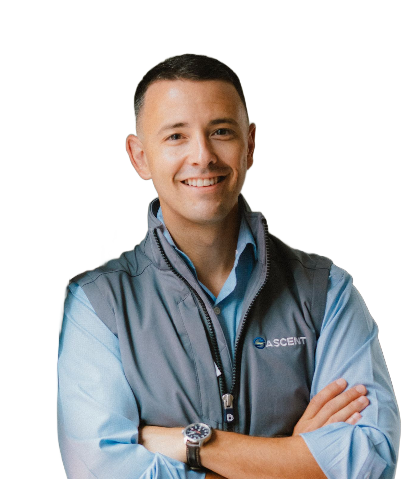 A smiling person with crossed arms wearing a light blue button-down shirt and gray vest with an Ascend logo.