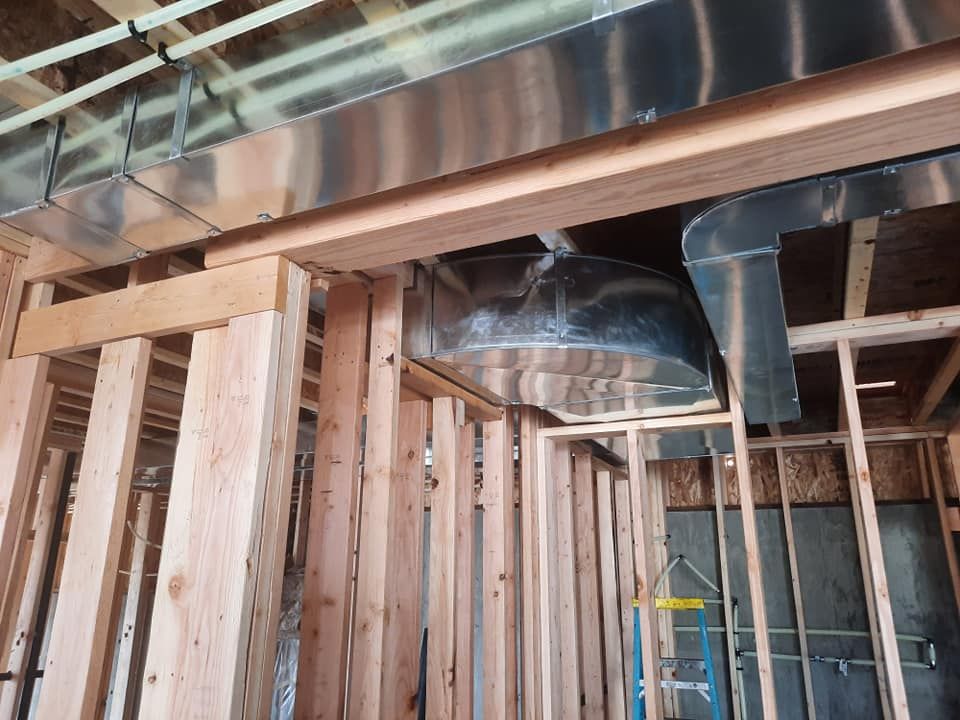 A house is being built with wooden beams and stainless steel pipes.