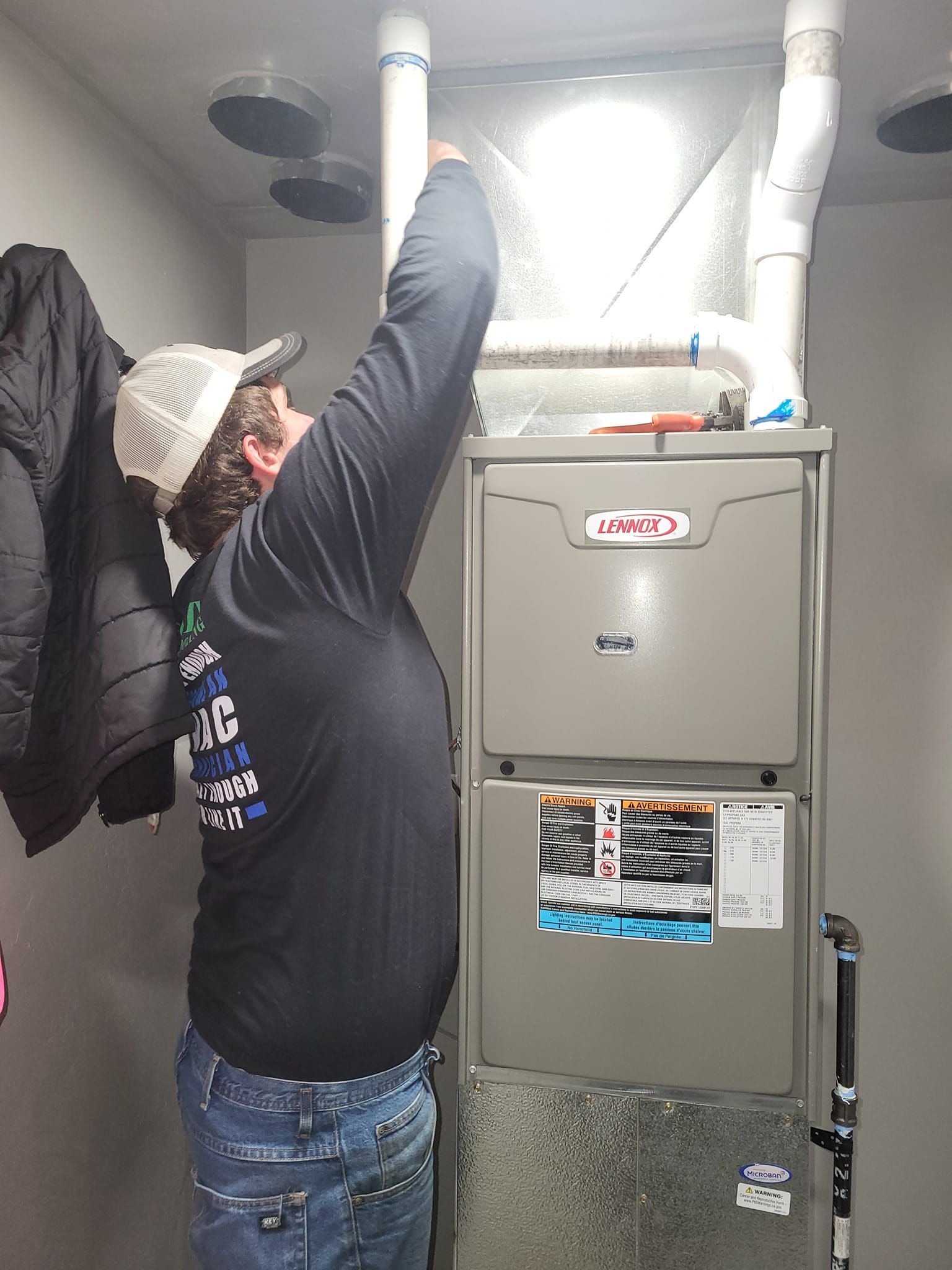 A man is working on a furnace in a basement.