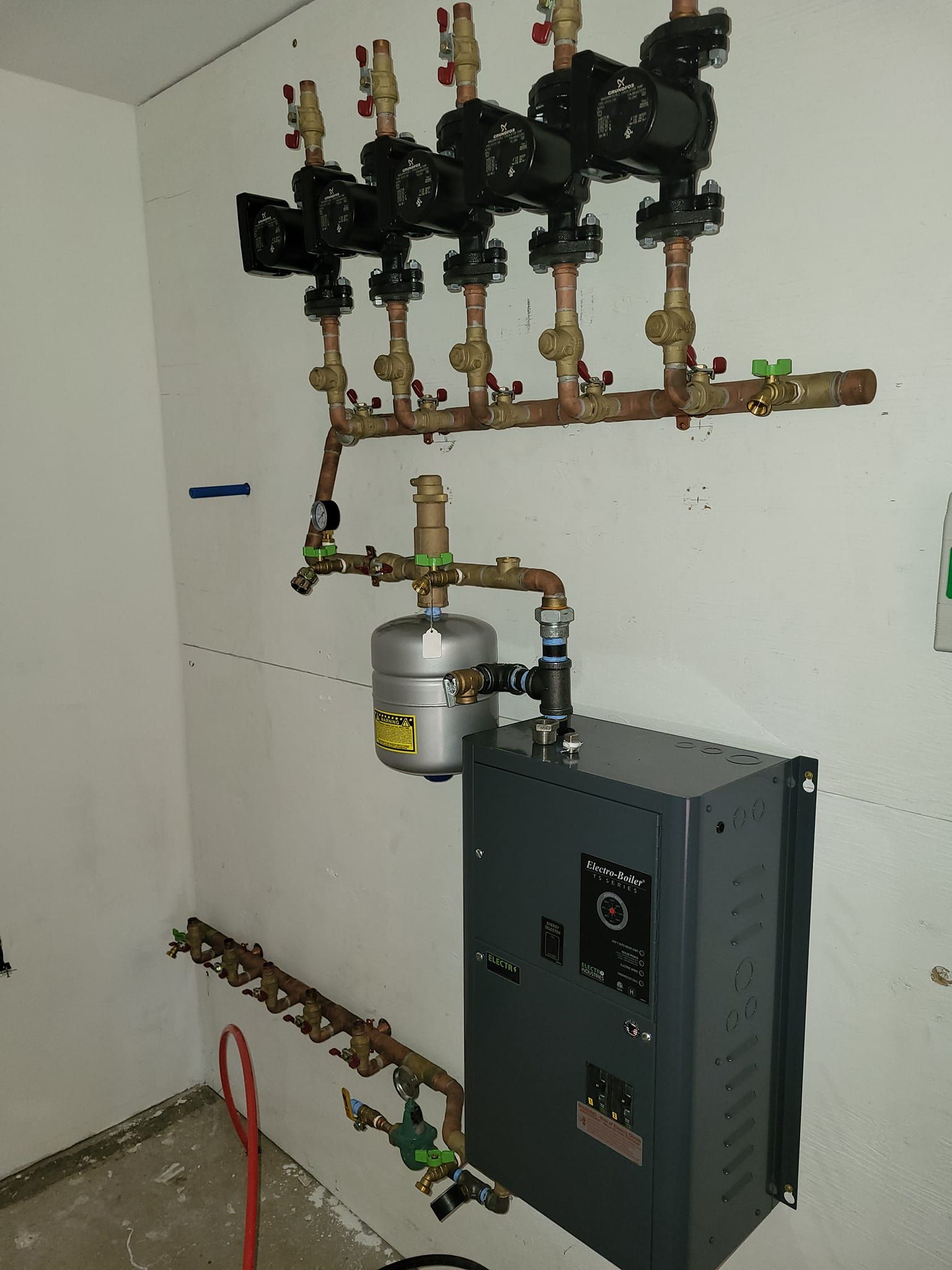 A room with a lot of pipes hanging from the wall