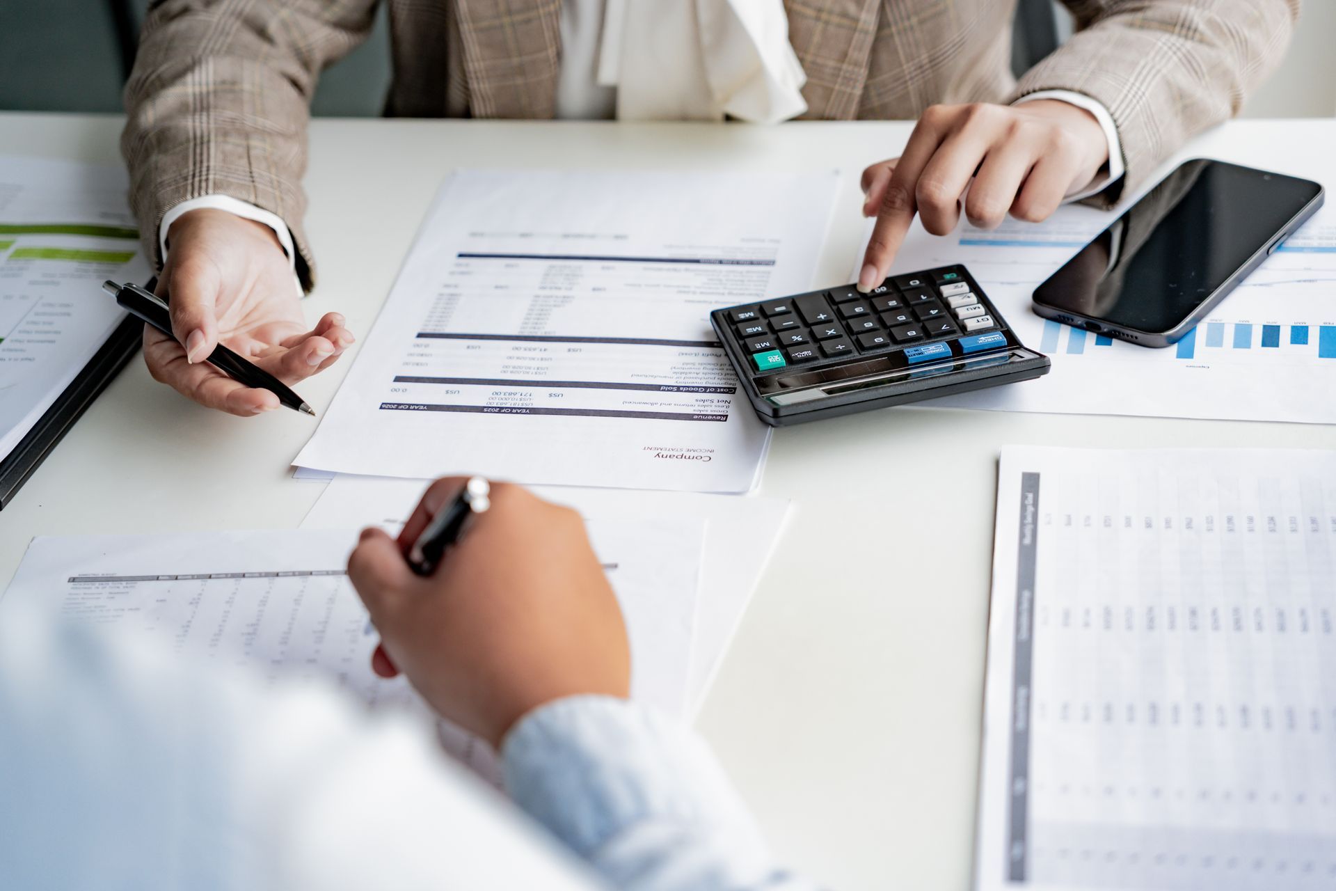 Person working on laptop with tax icons overlaid, indicating tax preparation.