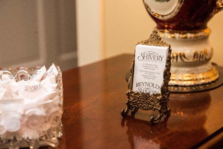 Table with a container of wrapped mints and a framed card reading 