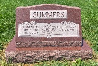 Red granite upright headstone for Eugene C. and Ruth Hanna Summers, engraved with their names and dates on grass.