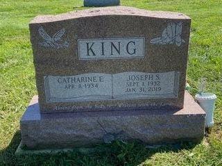 A red granite headstone inscribed