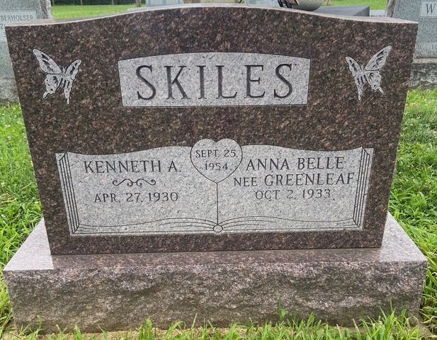 A dark, polished granite headstone engraved with