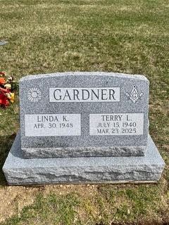 A grey granite upright headstone for the Gardner family, inscribed with dates for Linda K. and Terry L. Gardner.
