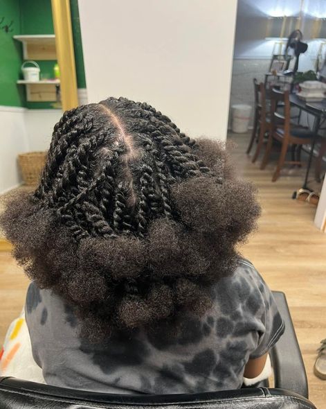 Braided hair styled into a neat updo, seen from behind in a home dining area.