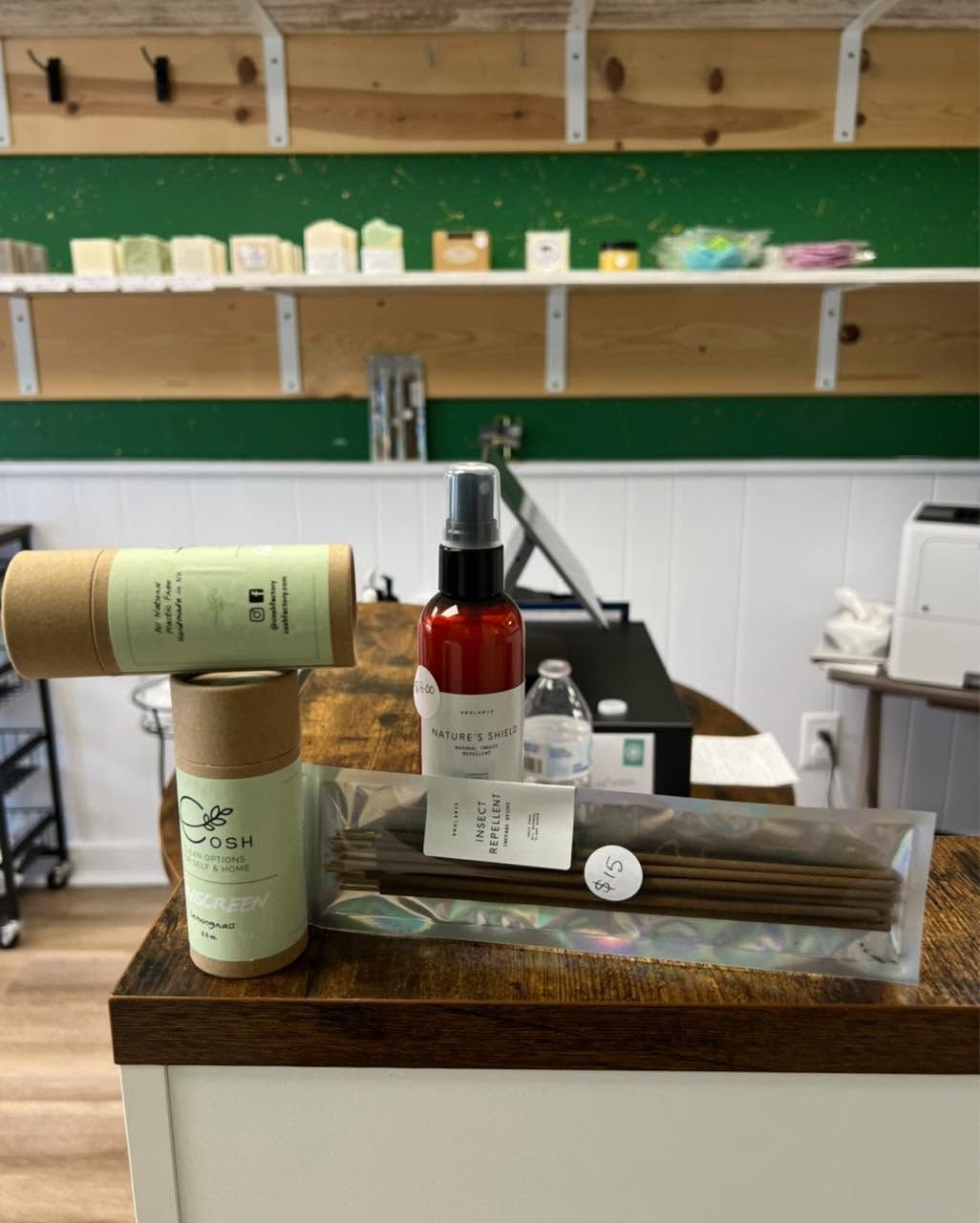 Wooden display of grooming products with bottles, boxes, and a soap bar on a shelf in a shop.