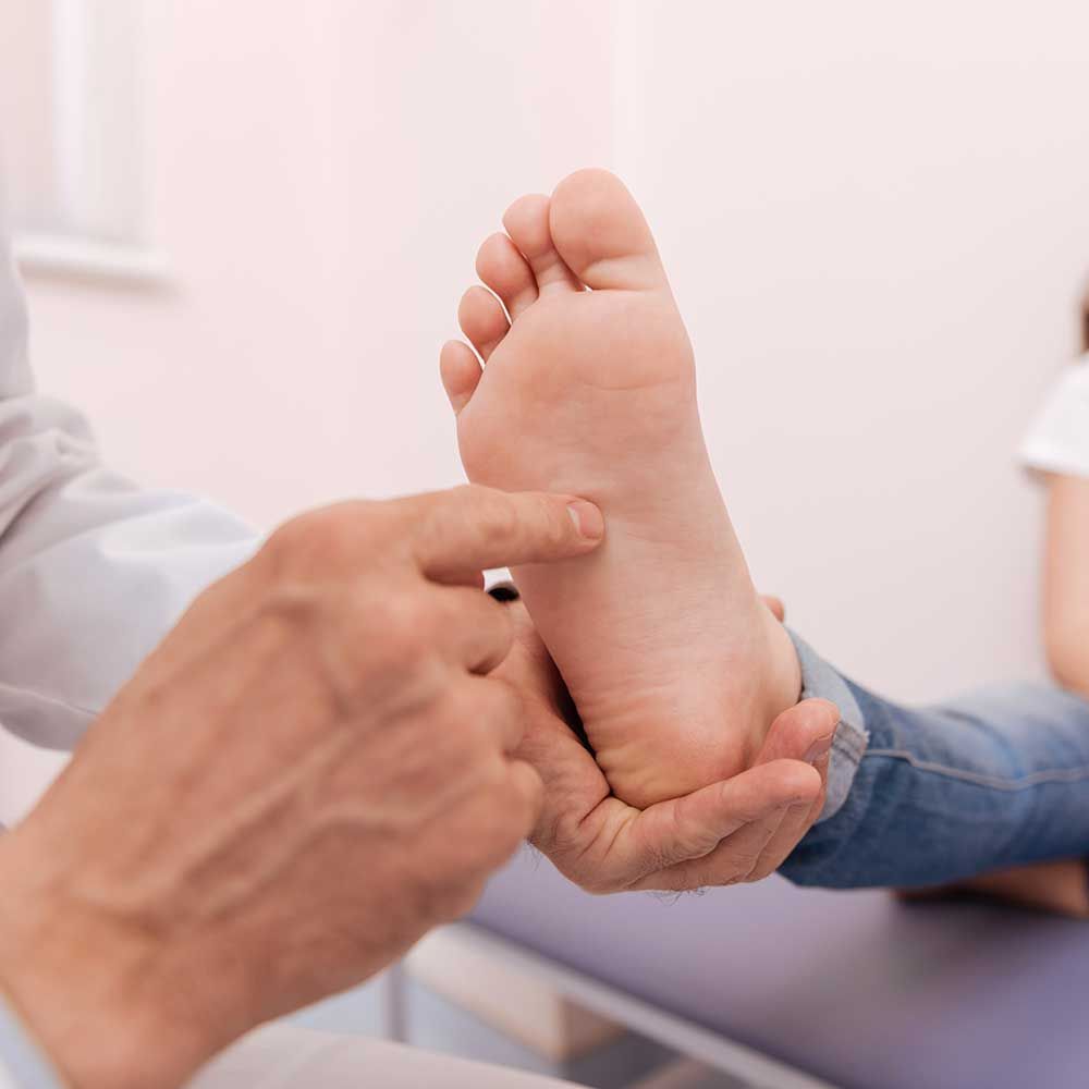 An experienced foot doctor running a checkup on child's foot in the Watertown, CT area