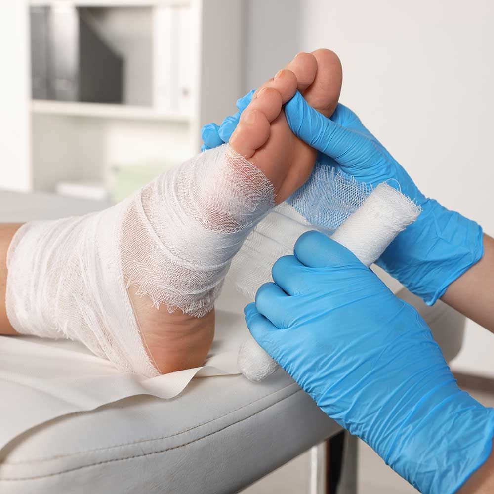 A diabetic podiatrist applying a bandage to a patient's foot