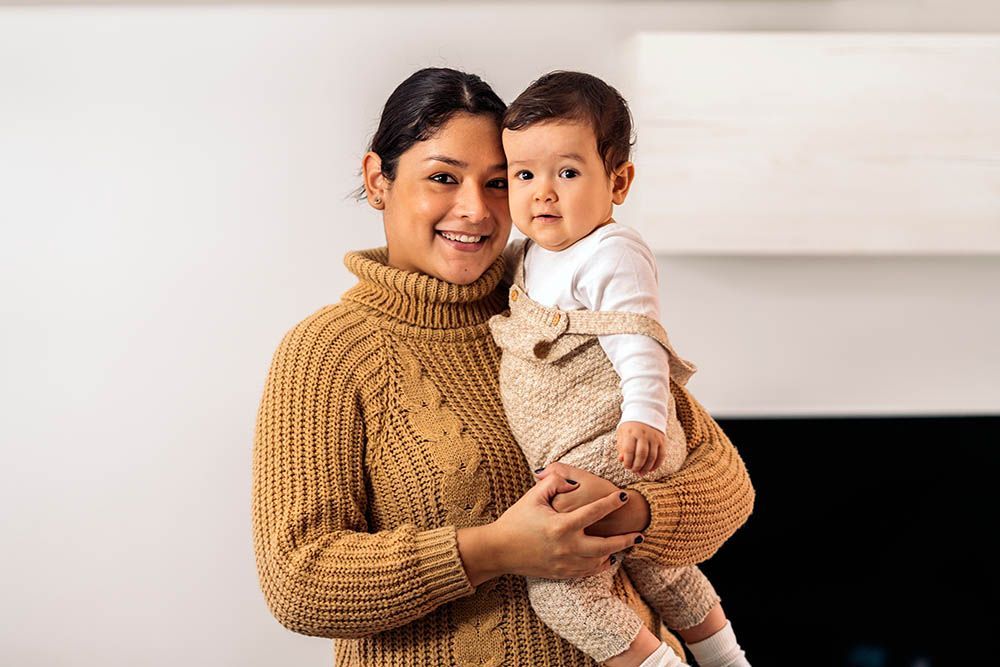 A woman is holding a baby in her arms.
